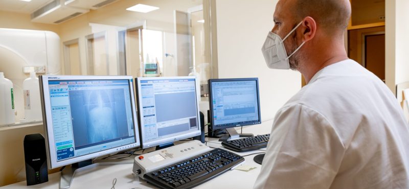 Profesional del Centro Diagnóstico Granada revisando monitores de ordenador mientras hace un TAC